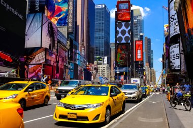 Times Meydanı 'nda güzel bir yaz günü, sarı New York taksileri renkli reklam panolarının içinden geçiyor. Manhattan, New York.