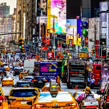 Times Meydanı 'nda sarı New York taksileri renkli reklam panolarından geçiyor. Manhattan, New York.