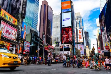 Times Meydanı 'nda güzel bir yaz günü, sarı New York taksileri renkli reklam panolarının içinden geçiyor. Manhattan, New York.