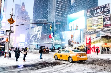 New York 'ta kar fırtınası sırasında New York City' nin sarı taksisiyle Times Meydanı 'na şiddetli kar yağışı, Manhattan' da kar fırtınası sırasında arabaların üzeri karla kaplı..
