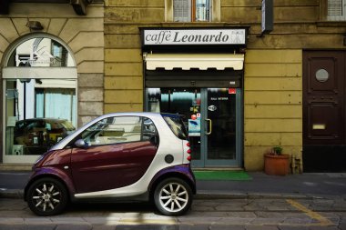 Milan, İtalya 'da güneşli bir günde Milan tramvayı, yayalar ve arabalarla dolu bir panorama.