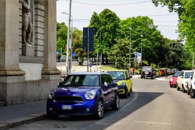 Milan, İtalya 'da güneşli bir günde Milan tramvayı, yayalar ve arabalarla dolu bir panorama