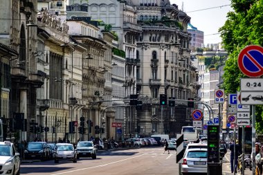 Milan, İtalya 'da güneşli bir günde Milan tramvayı, yayalar ve arabalarla dolu bir panorama