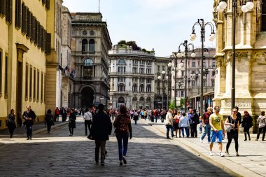 Milan, İtalya 'da güneşli bir günde Milan tramvayı, yayalar ve arabalarla dolu bir panorama