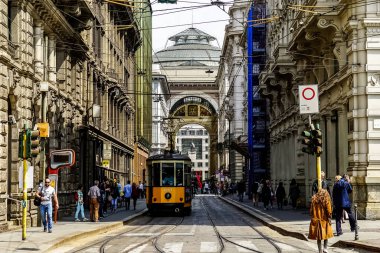 Milan, İtalya 'da güneşli bir günde Milan tramvayı, yayalar ve arabalarla dolu bir panorama