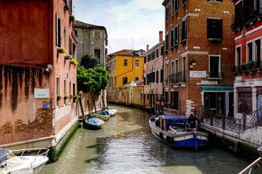 Venedik 'te küçük dar kanallar, botlar ve İtalya' daki köprülerin altında yüzen gondollarla dolu güzel bir gün..