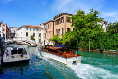 Venedik 'te küçük dar kanallar, botlar ve İtalya' daki köprülerin altında yüzen gondollarla dolu güzel bir gün..