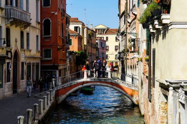 Venedik 'te küçük dar kanallar, botlar ve İtalya' daki köprülerin altında yüzen gondollarla dolu güzel bir gün..