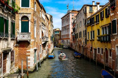 Venedik 'te küçük dar kanallar, botlar ve İtalya' daki köprülerin altında yüzen gondollarla dolu güzel bir gün..