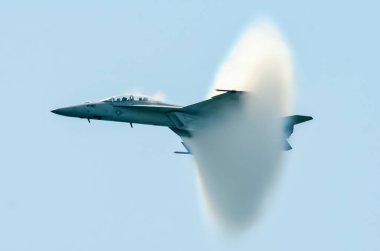 Jet ses duvarını geçiyor. McDonnell Douglas F-15 Eagle, Jones Beach State Park, Nassau County, ABD 'deki Jones Beach Hava Gösterisi sırasında buhar külahıyla ses bariyerini geçiyor..