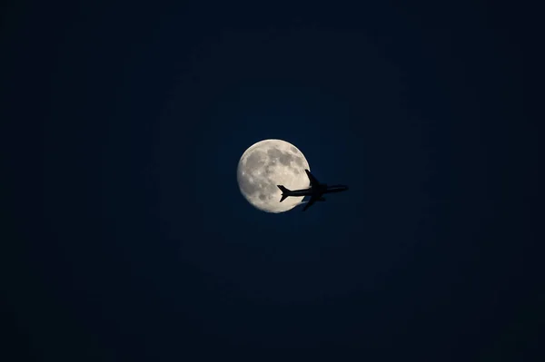 Pełnia Księżyca Przelatującym Przed Nią Samolotem — Zdjęcie stockowe