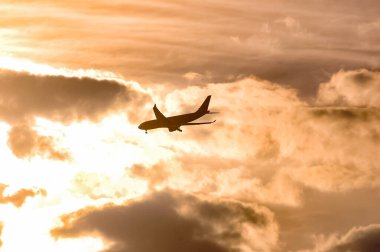 Gün batımında New York 'a inen uçak silueti. 