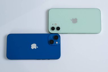 iPhone 13 mavi ve iPhone 12 yeşil. 