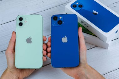 iPhone 13 mavi ve iPhone 12 yeşil. 