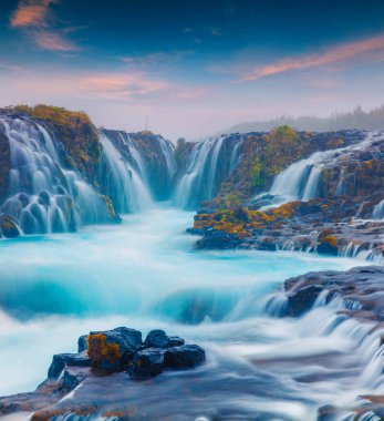 Eşsiz şelaleli gün batımı Bruarfoss. Güney İzlanda, Avrupa 'da renkli bir akşam sahnesi. İşlenmiş fotoğraf sonrası sanatsal stil.