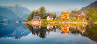 Gessl köyünün parlak güneşli manzarası. Grundlsee Gölü 'nün renkli yaz manzarası, Styria' nın Liezen Bölgesi, Avusturya, Alpler. Avrupa. İşlenmiş fotoğraf sonrası sanatsal stil.
