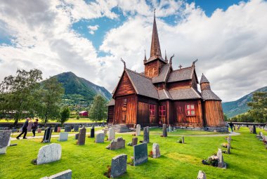Lom stave kilisesinin (Lom Stavkyrkje) resimli yaz manzarası. Norveç kırsalının güneşli sabah manzarası, Lom belediyesinin idari merkezi - Fossbergom, Norveç, Avrupa.