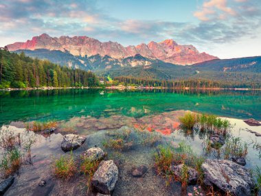 Zugspitze sıradağlarıyla Eibsee gölünde renkli bir yaz gündoğumu. Alman Alpleri, Bavyera, Garmisch-Partenkirchen köyü, Almanya, Avrupa 'da muhteşem bir açık hava sahnesi. İşlenmiş fotoğraf sonrası sanatsal stil.