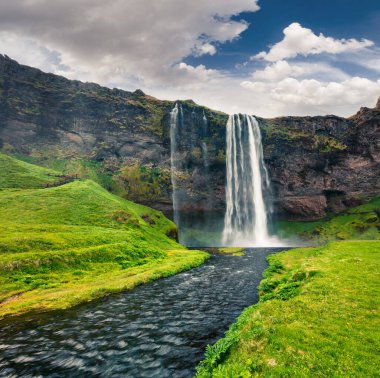 Seljalandfoss Şelalesi 'nin Seljalandsa nehri üzerindeki güzel sabah manzarası. İzlanda, Avrupa 'nın güney sahillerinde renkli bir yaz manzarası. İşlenmiş fotoğraf sonrası sanatsal stil.