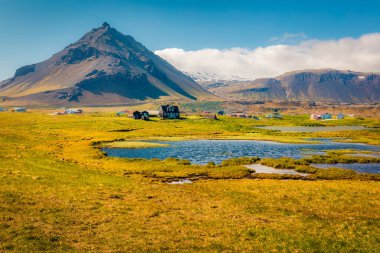 Majesti Dağı eteğindeki küçük balıkçı köyünün yaz manzarası. Stapafell - Arnarstapi veya Stapi. İzlanda kırsalının harika sabah manzarası. Seyahat konsepti arka planı.