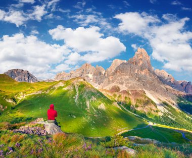 Pale di San Martino Zirvesi 'nin manzarasına hayran olan dağcı. Dolomite Alplerinde renkli bir yaz sabahı, San Martino di Castrozza köyü, İtalya. Doğa konseptinin güzelliği