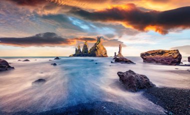 Atlantik Okyanusu 'ndaki Reynisdrangar kayalıklarında inanılmaz yaz günbatımı. İzlanda, Vik, Avrupa 'daki siyah kumsal sahnesinin dramatik sabah sahnesi. Doğa konseptinin güzelliği.
