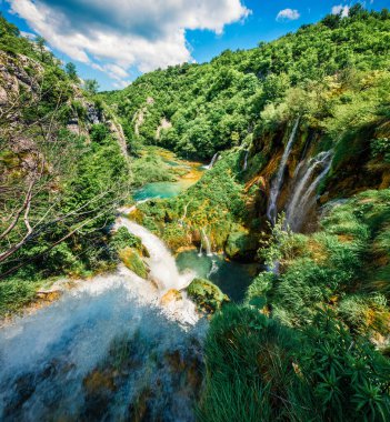 Plitvice Ulusal Parkı 'nın muhteşem sabah manzarası. Saf su gölü ve şelaleli yeşil ormanın parlak bahar manzarası. Hırvatistan ve Avrupa 'nın kırsal manzarası harika. Seyahat konsepti arka planı.