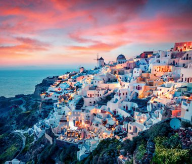 Santorini adasının etkileyici akşam manzarası. Yunanistan 'ın ünlü tatil beldesi Oia, Yunanistan ve Avrupa' da resim gibi bir bahar günbatımı. Seyahat konsepti geçmişi. İşlenmiş fotoğraf sonrası sanatsal stil