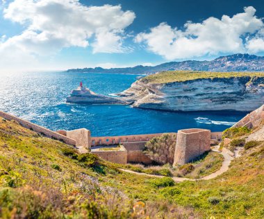 Arka planda Madonetta Feneri olan eski Bonifacio kalesinin güneşli öğleden sonra manzarası. Korsika adası, Fransa ve Avrupa 'nın büyüleyici bahar manzarası. Brigth Akdeniz manzarası.
