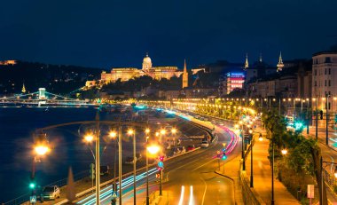 Tuna nehri üzerinde şehir ışıkları ve gemiyle Buda Kalesi 'nin akşam manzarası. Budapeşte, Macaristan, Avrupa 'daki renkli şehir manzarası. İşlenmiş fotoğraf sonrası sanatsal stil.