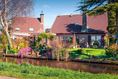 Tipik Hollanda kırsalının güneşli bahar manzarası. Ünlü yel değirmenleri müzesi Kinderdijk, Hollanda, Avrupa yakınlarındaki küçük Alblasserdam kasabasında renkli bir sabah sahnesi.