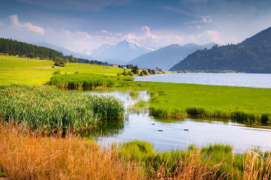 Ortler Zirvesi 'nin renkli yaz manzarası. Muta Gölü 'nde (Haidersee) sabah sisi, St. Valentin köyü konumu, Güney Tyrol, İtalya, Avrupa. İşlenmiş fotoğraf sonrası sanatsal stil