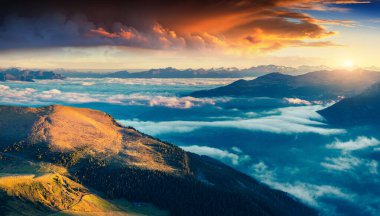 Dolomite Alplerinde renkli yaz gündoğumu. Noel Magdalena köyündeki Furchetta tepesinden sabah manzarası. Sis denizinin altında. Bolzano ili, Güney Tyrol, İtalya.