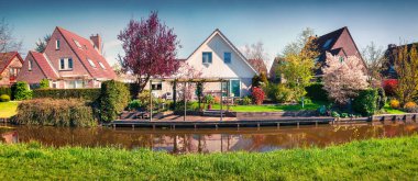 Tipik Hollanda kırsalının güneşli bahar manzarası. Ünlü yel değirmenleri müzesi Kinderdijk, Hollanda, Avrupa yakınlarındaki küçük Alblasserdam kasabasında renkli bir sabah sahnesi.