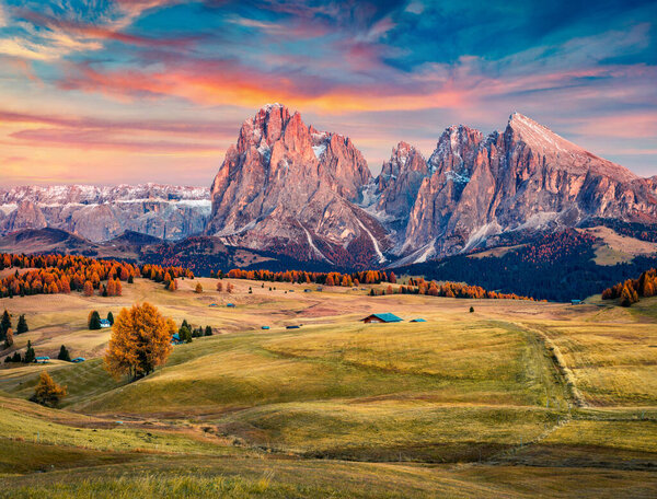Astonishing sunrise on Alpe di Siusi mountain plateau with Langkofel (Sassolungo) mountain on background. Beautiful autumn morning in Dolomite Alps, Ortisei locattion, Italy. Traveling concept background