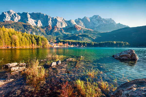 Marvelous evening scene of Eibsee lake with Zugspitze mountain range on background. Exciting autumn view of Bavarian Alps, Germany, Europe. Beauty of nature concept background.