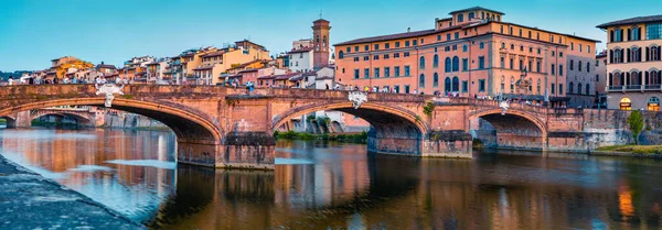Medieval arched river bridge with Roman origins - Ponte Santa Trinita over Arno river. Panoramic summer cityscape of Florence, Italy, Europe. Traveling concept background.