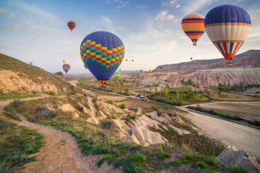 Sabahın erken saatlerinde Cappadocia 'da balonlarla uçmak. Kırmızı Gül Vadisi, Goreme Köyü, Türkiye, Asya 'da renkli gündoğumu. İşlenmiş fotoğraf sonrası sanatsal stil.
