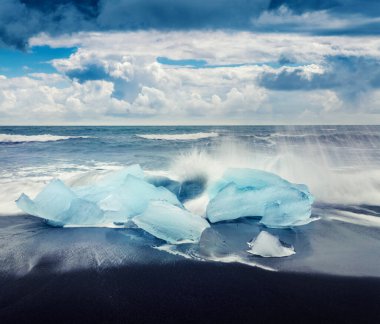 Jokulsarlon sahilindeki dalgalarla yıkanmış buz blokları. Vatnajokull Ulusal Parkı, İzlanda, Avrupa 'da dramatik bir yaz sabahı. İşlenmiş fotoğraf sonrası sanatsal stil.