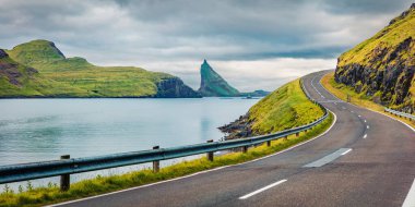 Arka planda Faroe Adaları ve Tindholmur uçurumlarının kasvetli yaz sahnesi. Vagar Adası, Danimarka Krallığı, Avrupa 'nın panoramik sabah manzarası. Seyahat konsepti arka planı