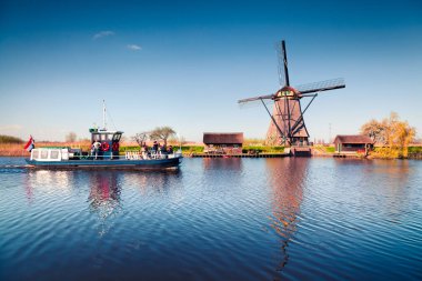 Hollanda 'daki Kinderdijk Müzesi' ndeki ünlü zihin değirmenleri. Kırsal kesimde güneşli bir bahar sabahı. Hollanda, Avrupa 'da renkli bir açık hava sahnesi. UNESCO Dünya Mirası Alanı. İşlenmiş fotoğraf sonrası sanatsal stil.
