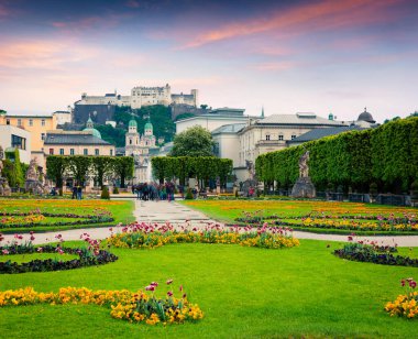 Salzburg Katedrali 'nin akşam manzarası ve Mirabell Garden' dan tarihi Hohensalzburg Kalesi. Avusturya, Avrupa 'da renkli gün batımı. İşlenmiş fotoğraf sonrası sanatsal stil.