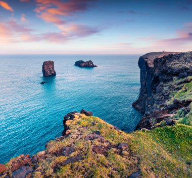 Dyrholaey Doğa Koruma Alanı 'nda renkli bir yaz sabahı. Dyrholaey kemerinin harika manzarası, İzlanda 'nın güney kıyısı, Avrupa. İşlenmiş fotoğraf sonrası sanatsal stil.