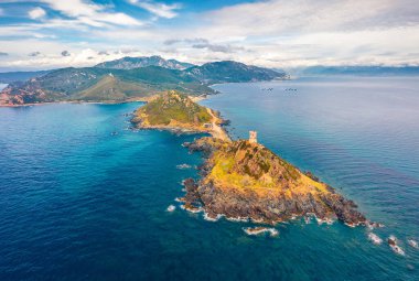 Uçan İHA 'nın görüntüsü. Popüler turizm beldesi Torra di a Parata 'nın inanılmaz bahar manzarası. 16. yüzyıl Ceneviz Kulesi kayalık doğa yolu, Korsika Adası, Fransa, Avrupa.