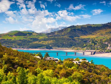 Serre-Poncon Gölü 'nün güneşli bahar manzarası. Fransız Alpleri, Savines-le-Lac köyü, Fransa, Avrupa 'da resim gibi bir sabah sahnesi. Doğa konseptinin güzelliği
