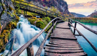 Plitvice Ulusal Parkı 'ndaki saf su şelalesinin büyüleyici akşam manzarası. Hırvatistan, Avrupa 'da muhteşem sonbahar günbatımı. Doğa konseptinin güzelliği.