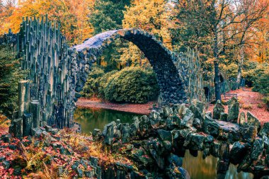 Azalea ve Rhododendron Park Kromlau 'nun muhteşem sabah manzarası, Almanya, Avrupa. Rakotz Köprüsü 'nün (Rakotzbrucke, Şeytanın Köprüsü) muhteşem sonbahar sahnesi. Seyahat konsepti arka planı.