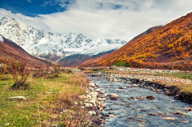 Shkhara Dağı 'nın güney eteklerinde. Ushguli köyünden görüntü. Kafkasya dağlarında renkli bir sonbahar sabahı, Yukarı Svaneti, Gürcistan, Avrupa. İşlenmiş fotoğraf sonrası sanatsal stil.