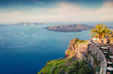 Santorini adasının güneşli sabah manzarası. Yunanistan 'ın ünlü tatil beldesi Thira, Yunanistan ve Avrupa' da resim gibi bir bahar gündoğumu. Seyahat konsepti geçmişi. İşlenmiş fotoğraf sonrası sanatsal stil.