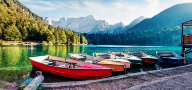 Fusine Gölü 'nde altı tane eğlence teknesi. Julian Alps 'in panoramik akşam sahnesi. Arka planda Mangart zirvesi, Udine ili, İtalya, Avrupa. Seyahat konsepti arka planı.